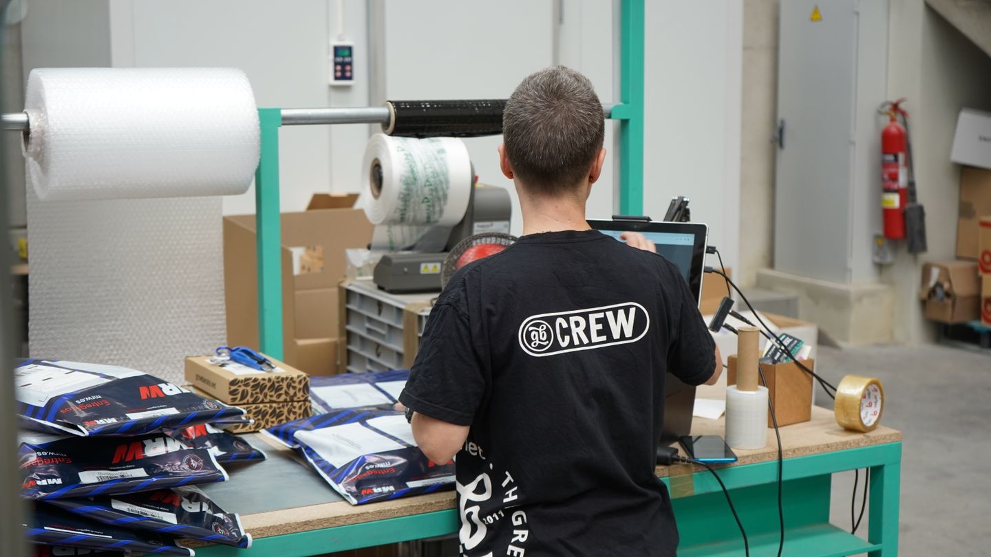 Warehouse employee using a computer to manage inventory operations.